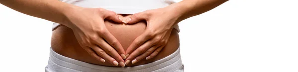 Woman holding her hands in a heart shape on her pregnant belly — Stock Photo, Image