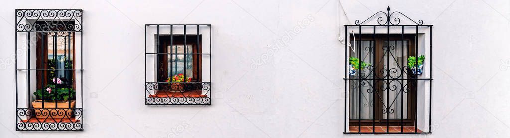 Windows with steel lattice on a whitewashed wall