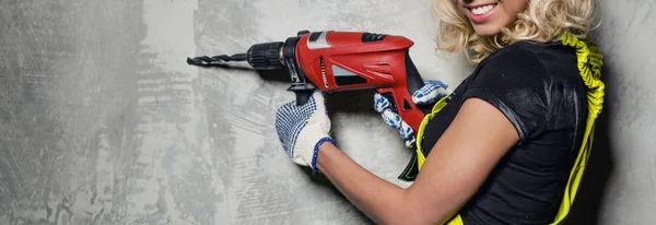 Attractive builder woman with a drill horizontal image — Stock Photo, Image