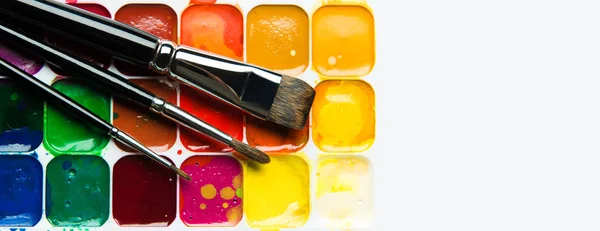 Watercolor paintbox and paintbrushes panorama on white — Stock Photo, Image