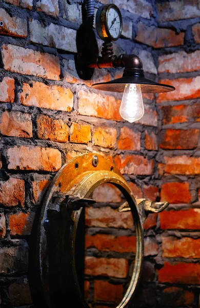 Steampunk stile interior design lampada e specchio sopra muro di mattoni rossi — Foto Stock