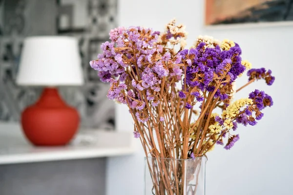 Pretty violet flowers in glass vase at home