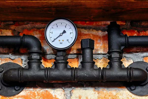 Staré černé potrubí a tlakoměr — Stock fotografie