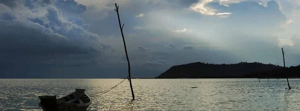 Nubes tormentosas sobre el mar, silueta de barco solitario en el agua — Foto de Stock