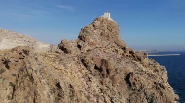 Kayanın üst kısmında Mesa Roldan Lighthouse ünlü pitoresk inşaat bulunan uçurumun etrafında drone video, kuşların sürüsü, Cabo de Gata-Nijar Natural Park, Almeria Eyaleti, Endülüs. İspanya