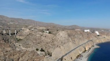 Endülüs 'te Ispanya 'nın güneyindeki Almeria 'nın Rocky manzarası. Deniz kıyısı Kayalık Dağları ile manzara gerçek zamanlı video ana yol karayolu hava drone noktası kurak iklim Akdeniz deniz manzarası, güneşli gün