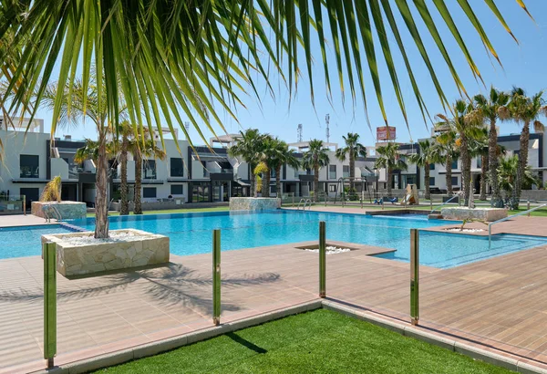 Vista a casas adosadas modernas de nueva construcción urbanización cerrada con palmeras de piscina, edificio residencial de lujo exterior, Torrevieja, provincia de Alicante, España — Foto de Stock