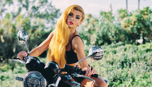 Seksowna blond młoda kobieta ubrana w czarną bieliznę siedzącą na motocyklu — Zdjęcie stockowe