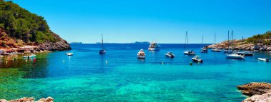 Panorama of sailboats at Cala Salada lagoon clipart