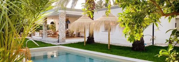 Panoramic image inner garden with private swimming pool straw parasol beautiful luxury wealthy residential summer villa, sunny day, no people. Spain — Stock Photo, Image