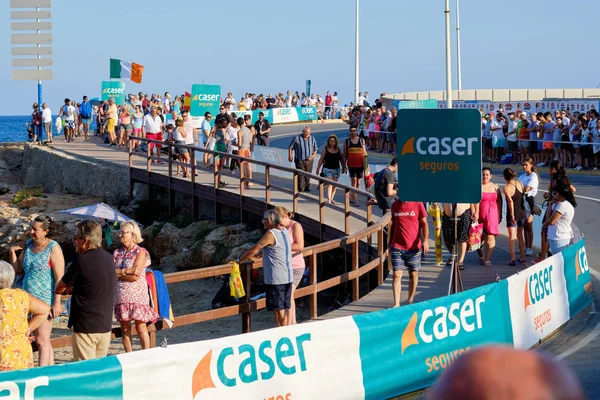 Mucha gente caminando a lo largo de la costa cerca del mar Mediterráneo durante el evento La Vuelta — Foto de Stock