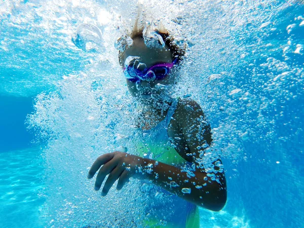 Petite fille entourée de bulles à l'intérieur de la piscine — Photo