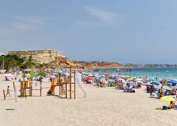 İnsanlar kumlu plaj Campoamor yaz tatilleri tadını çıkarın — Stok fotoğraf