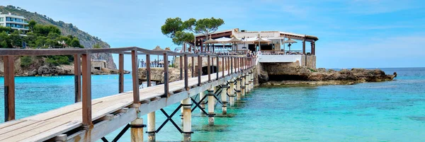 Wooden walkway leading across turquoise Mediterranean Sea panorama