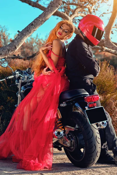 Kvinna och man som sitter på motorcykel poserar på naturen — Stockfoto