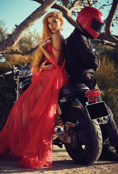 Vrouw en man zittend op motorfiets poseren op de natuur — Stockfoto