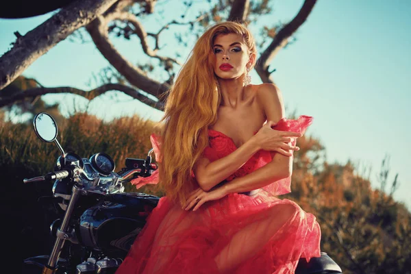 Hermosa mujer con vestido posando sentado en la motocicleta al aire libre — Foto de Stock