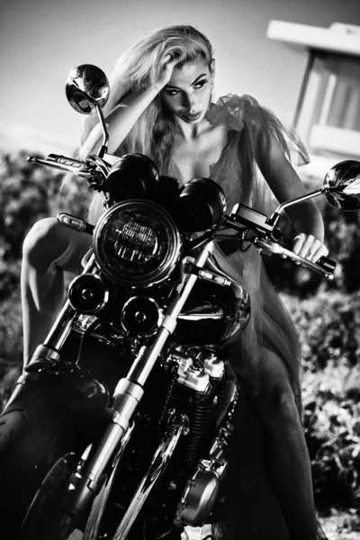 Prachtige vrouw dragen rode pluizige jurk zittend op motorfiets — Stockfoto