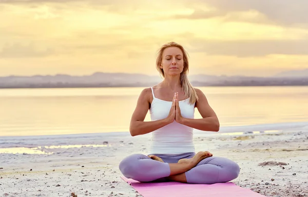 Betagte Frau in Lotusposition meditiert über die Natur — Stockfoto