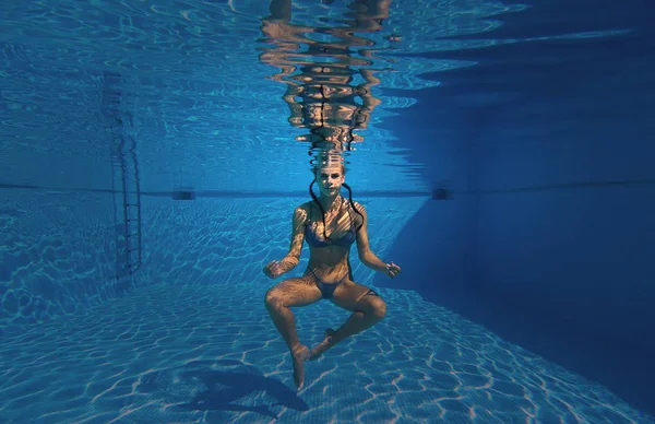 Mulher vestindo maiô fazer meditação sobre a profundidade da piscina — Fotografia de Stock