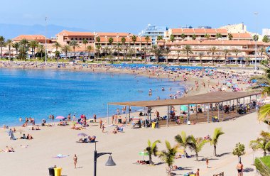 Playa de los Cristianos kumsalında güneşlenen insanlar.