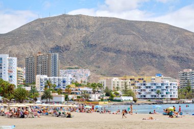 Playa de los Cristianos kumsalında güneşlenen insanlar.