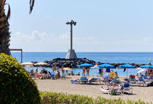 Playa de los Cristianos kumsalında güneşlenen insanlar. — Stok fotoğraf