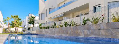 Torrevieja, İspanya - 2 Haziran 2020: Banner view modern yüzme havuzlu konut kompleksi. Kiralık daire kavramı yaz tatili, yeni ev, kredi. İnsan yok. İspanya Costa Blanca. Espana