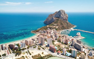 Aerial photography Penyal d'Ifac Natural Park, Calpe townscape turquoise bright Mediterranean Sea waters, residential buildings. Province of Alicante, Costa Blanca, Spain. Travel and landmark concept clipart