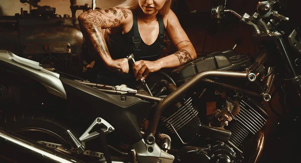 年轻迷人的金发女机修工在车间修理摩托车 职业和生活方式概念 — 图库照片