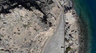 Cabo de Gata Akdeniz Turkuaz Körfezi 'nin yukarısından doğrudan manzarayı izleyin. Kıvrımlı dağ yolu, güneşli bir günde kayalık dağın etrafından dolaşır. İnsansız hava aracı manzarası, İspanya, Avrupa, Almerya