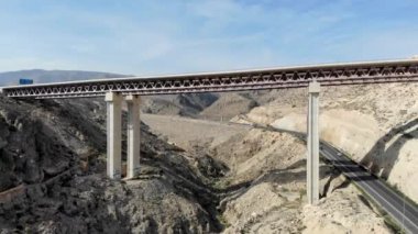Güneşli, huzurlu bir gün manzarası, viyadük köprüsüne. Vadi boyunca uzanan yüksek insansız hava aracı manzaralı kayalık dağlar. Almerya, Endülüs, İspanya