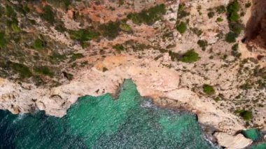Hava aracı doğrudan yukarıdan kayalık kıyı şeridi ve turkuaz Akdeniz 'i gösteriyor. Yeşil göl suyu, güneşli bir gün, insan yok. Costa Blanca manzarası, İspanya