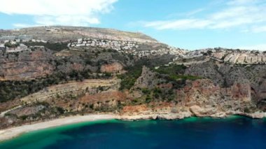Benitachell sahil kasabasındaki hava aracı Cala de Moraig 'e bakıyor. Parlak turkuaz Akdeniz lagünü boş beyaz kumlu plaj, devasa uçurumlar sade kıyı şeridi. Costa Blanca 'da. İspanya
