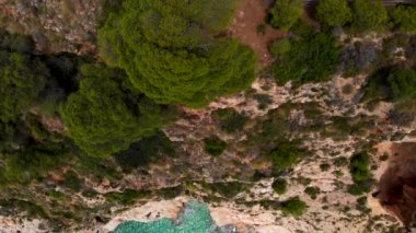 Hava aracı doğrudan yukarıdan kayalık kıyı şeridi ve turkuaz Akdeniz 'i gösteriyor. Yeşil göl suyu, güneşli bir gün, insan yok. Costa Blanca manzarası, İspanya