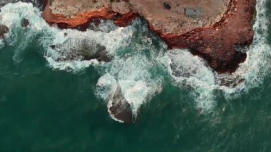 Torrevieja tatil beldesinin kayalık kıyı şeridine doğrudan yukarıdan bakan insansız hava aracı dalgaları kırıyor, gün doğumunda Akdeniz 'de sörf yapıyor. Alicante ili, Costa Blanca, İspanya