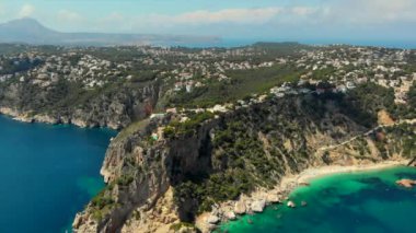 İnsansız hava aracının resmi turkuaz körfez yeşil su lagünü Akdeniz kayalık kıyı şeridi, şnorkelle yüzmek ve yüzmek için sakin Ambolo plajı, sıcak yaz günü. Costa Blanca, İspanya