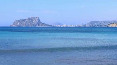 Waterside, Calpe tatil köyü, Penyal de Ifac kayalık dağı, açık mavi gökyüzü. Akdeniz sörf suyu hareketleri. Güneşli bir yaz günü. Alicante ili, Costa Blanca, İspanya