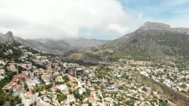 Gerçek zamanlı panoramik geniş açılı Calpe yamacı evleri panorama kayalık dağlar bulutlu gökyüzü. Alicante ili, Costa Blanca, İspanya