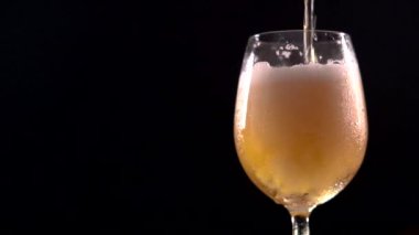 Bira, siyah arkaplanda yavaş çekim görüntüsüne dökülüyor.