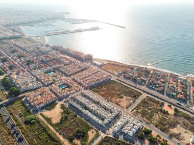 Güneş doğarken Torrevieja şehir manzarasının havadan çekilmiş fotoğrafı. Akdeniz manzarası ve liman manzarası yukarıdan. Alicante ili, Costa Blanca, İspanya