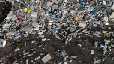 Rıhtım kenarındaki hava görüntüsü yığını. Üst taraftaki plastik şişelerin üzerinde göl kıyısındaki deniz atıkları çöplük. İnsansız hava aracı. Küresel hasar çevresel boşaltma kavramı