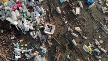 Rıhtım kenarındaki hava görüntüsü yığını. Üst taraftaki plastik şişelerin üzerinde göl kıyısındaki deniz atıkları çöplük. İnsansız hava aracı. Küresel hasar çevresel boşaltma kavramı