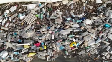 Rıhtım kenarındaki hava görüntüsü yığını. Üst taraftaki plastik şişelerin üzerinde göl kıyısındaki deniz atıkları çöplük. İnsansız hava aracı. Küresel hasar çevresel boşaltma kavramı