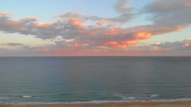 Kumlu kumsalın ve mavi sakin Akdeniz 'in resimli hava manzarası. Gün batımında parlayan pembe bulutlar, kumlu sahil şeridi. La Mata, Torrevieja, Costa Blanca, İspanya