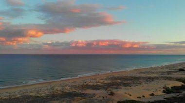 En tepeden kumsal manzarası. Drone 'un kıyı şeridi Akdeniz sörfü, pembe parlak, tüylü bulutlar mavi akşam gökyüzü. Alicante La Mata ili, Torrevieja, Costa Blanca, İspanya