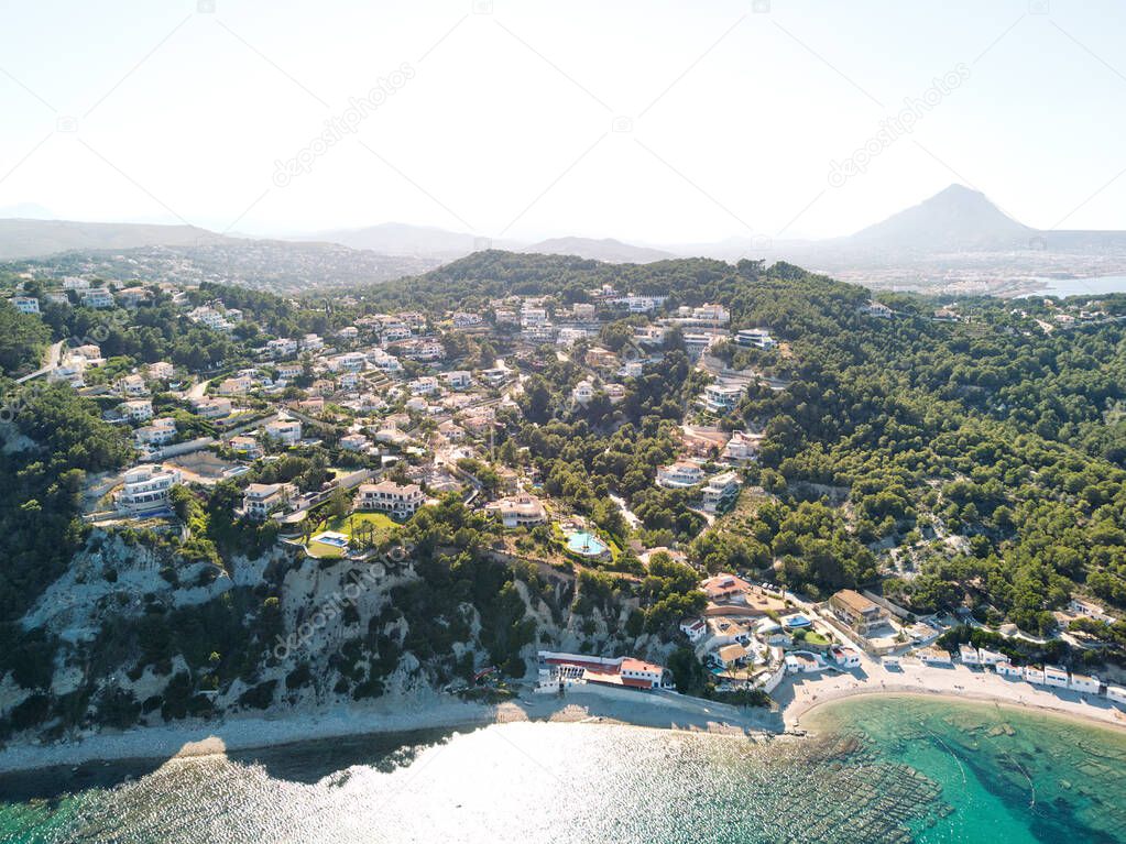 Hillside village on top of rocky mountains. Javea coastline view from above, aerial photography. Costa Blanca, Spain
