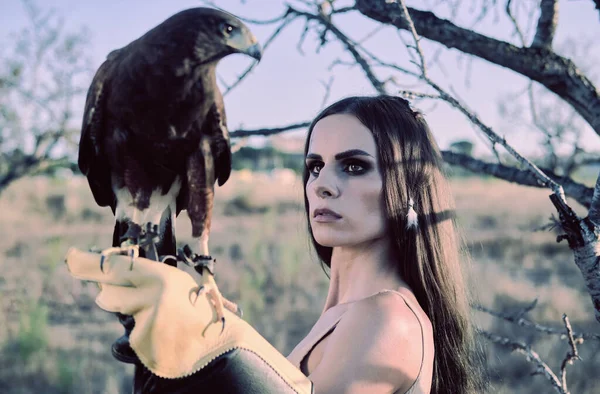 Beautiful woman posing on nature with eagle