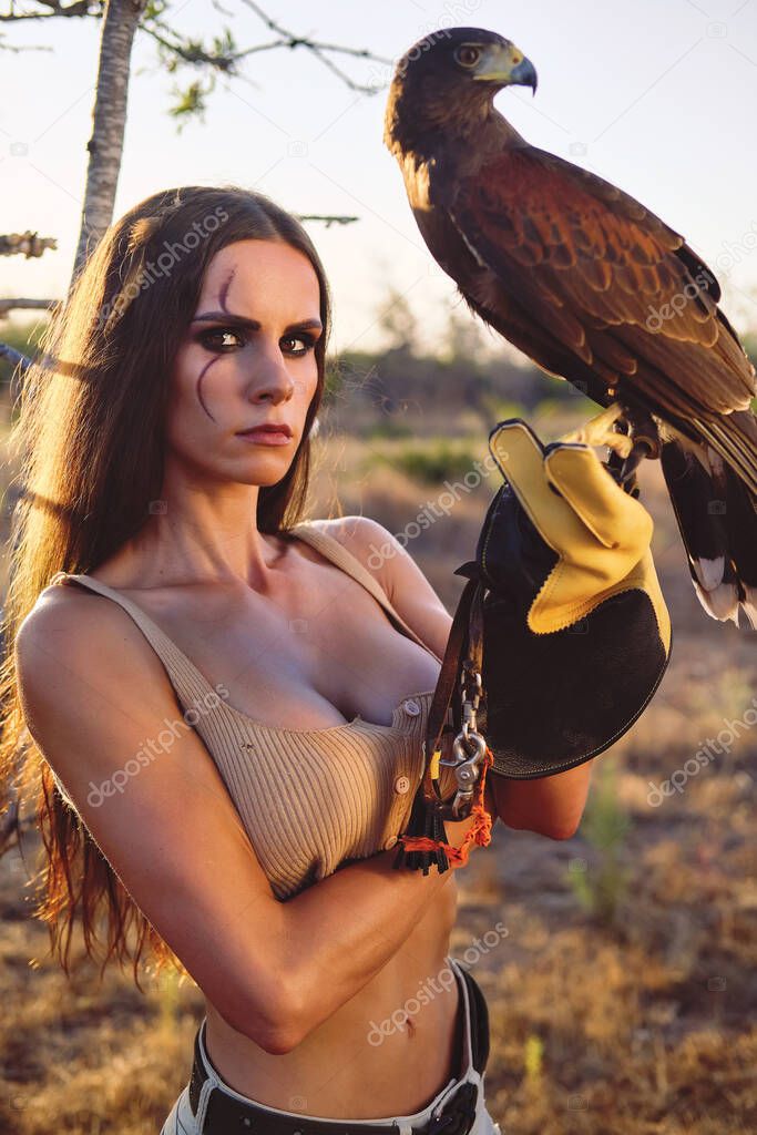 Beautiful woman posing on nature with eagle