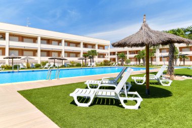 Torrevieja, İspanya - 2 Haziran 2020: Güneşli yaz gününde güverte sandalyeleri ve yüzme havuzlu boş alan. Seyahat ve yaz tatili konsepti